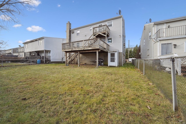 rear view of house featuring a deck and a yard