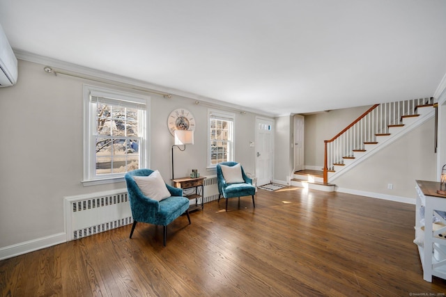 living area with radiator, crown molding, and dark hardwood / wood-style floors