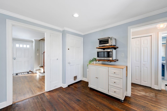 interior space featuring ornamental molding, white cabinets, and dark hardwood / wood-style floors