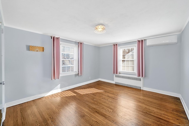 empty room with a wealth of natural light, radiator, hardwood / wood-style floors, and a wall mounted air conditioner