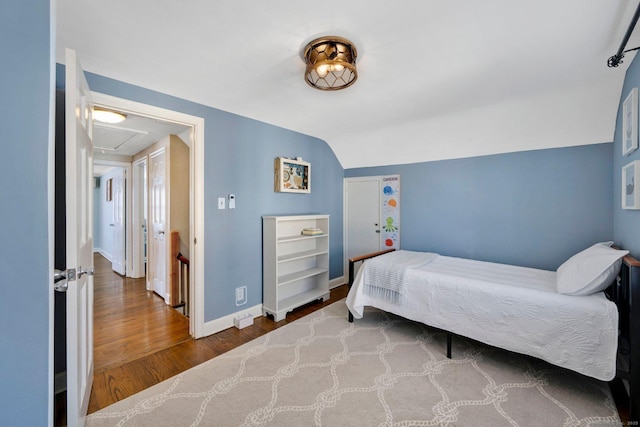 bedroom featuring lofted ceiling and hardwood / wood-style floors