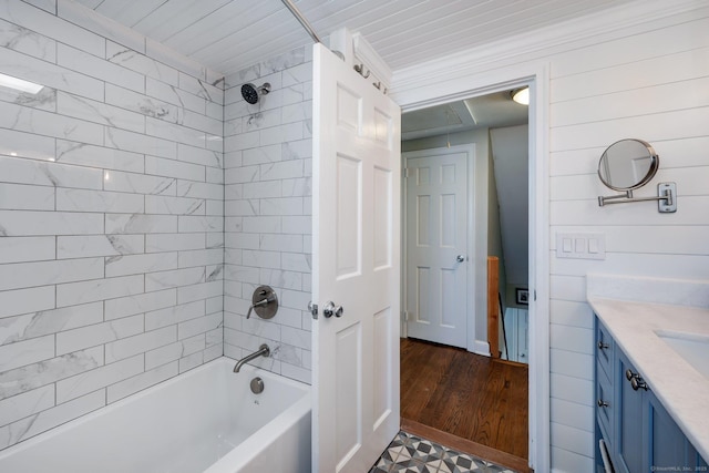 bathroom with tiled shower / bath, wood-type flooring, and vanity