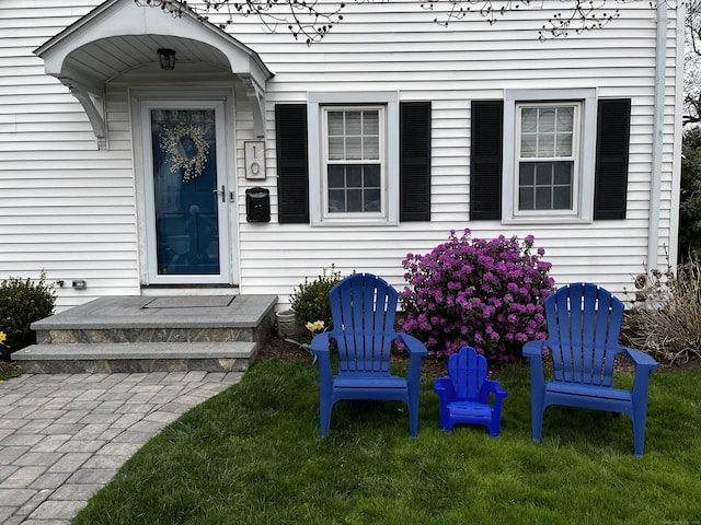 doorway to property featuring a lawn