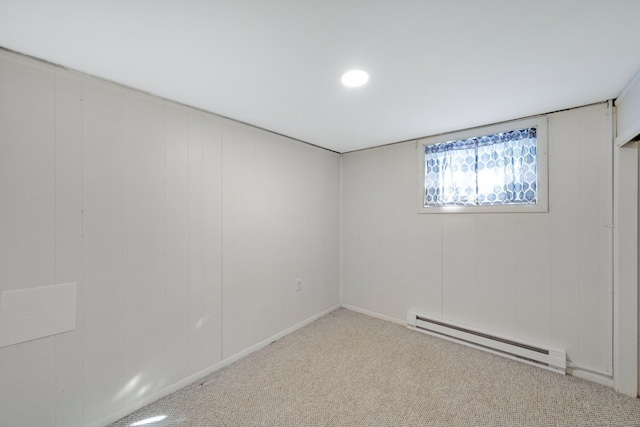 empty room with light colored carpet and a baseboard radiator