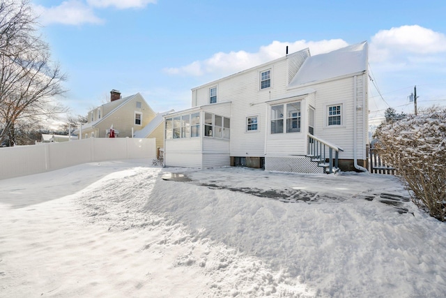 snow covered property with a sunroom