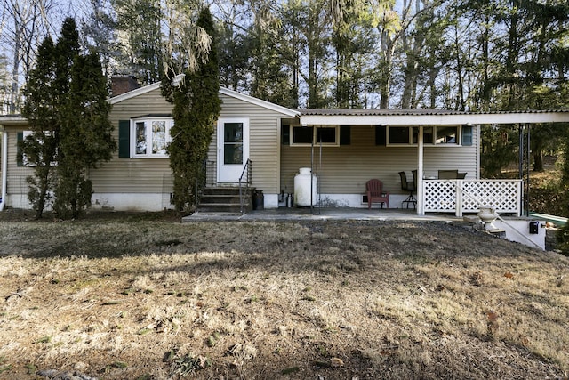 rear view of house featuring a lawn and a patio