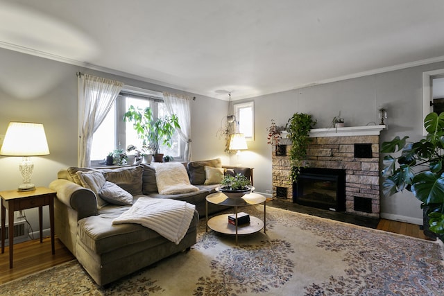 living room featuring ornamental molding, a fireplace, and hardwood / wood-style flooring