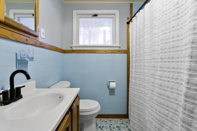 bathroom featuring toilet, a wealth of natural light, tile walls, and vanity