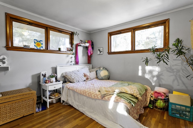 bedroom with ornamental molding and dark hardwood / wood-style floors