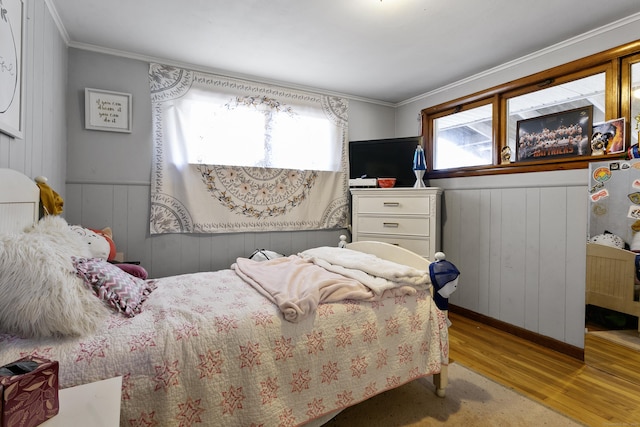 bedroom with ornamental molding and light hardwood / wood-style floors