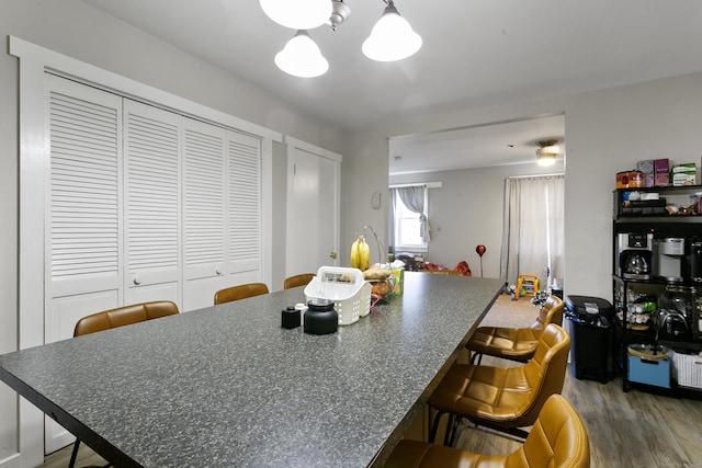 kitchen with a breakfast bar, hardwood / wood-style floors, and an inviting chandelier