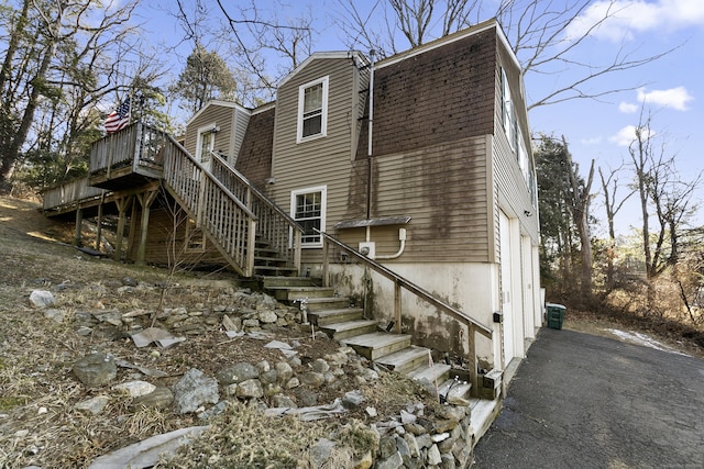 view of side of property featuring a garage and a wooden deck