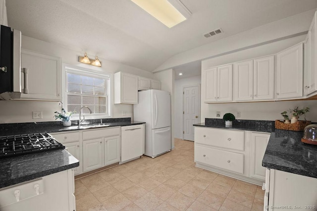 kitchen featuring white cabinetry, white appliances, vaulted ceiling, and sink