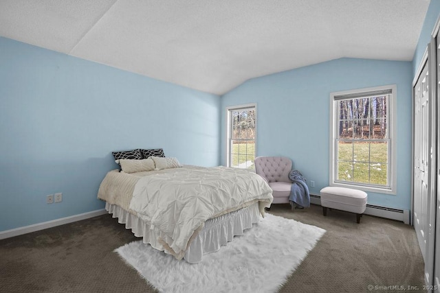 carpeted bedroom with a baseboard heating unit and vaulted ceiling