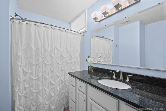 bathroom featuring vanity, a textured ceiling, and a shower with shower curtain