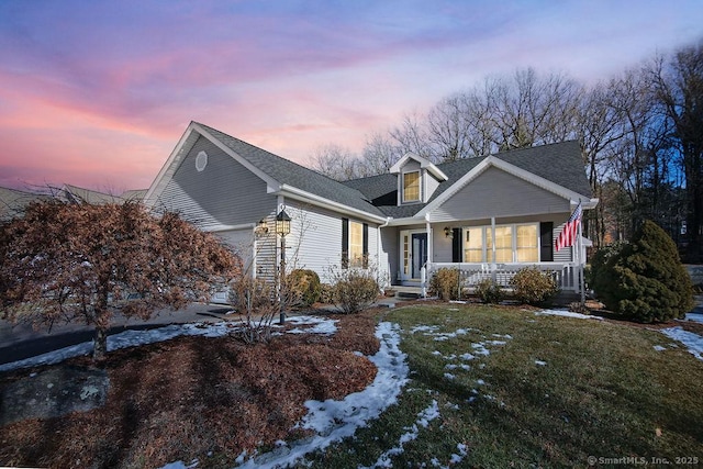 cape cod-style house with a yard and a porch