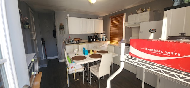 kitchen with dark hardwood / wood-style flooring and white cabinets