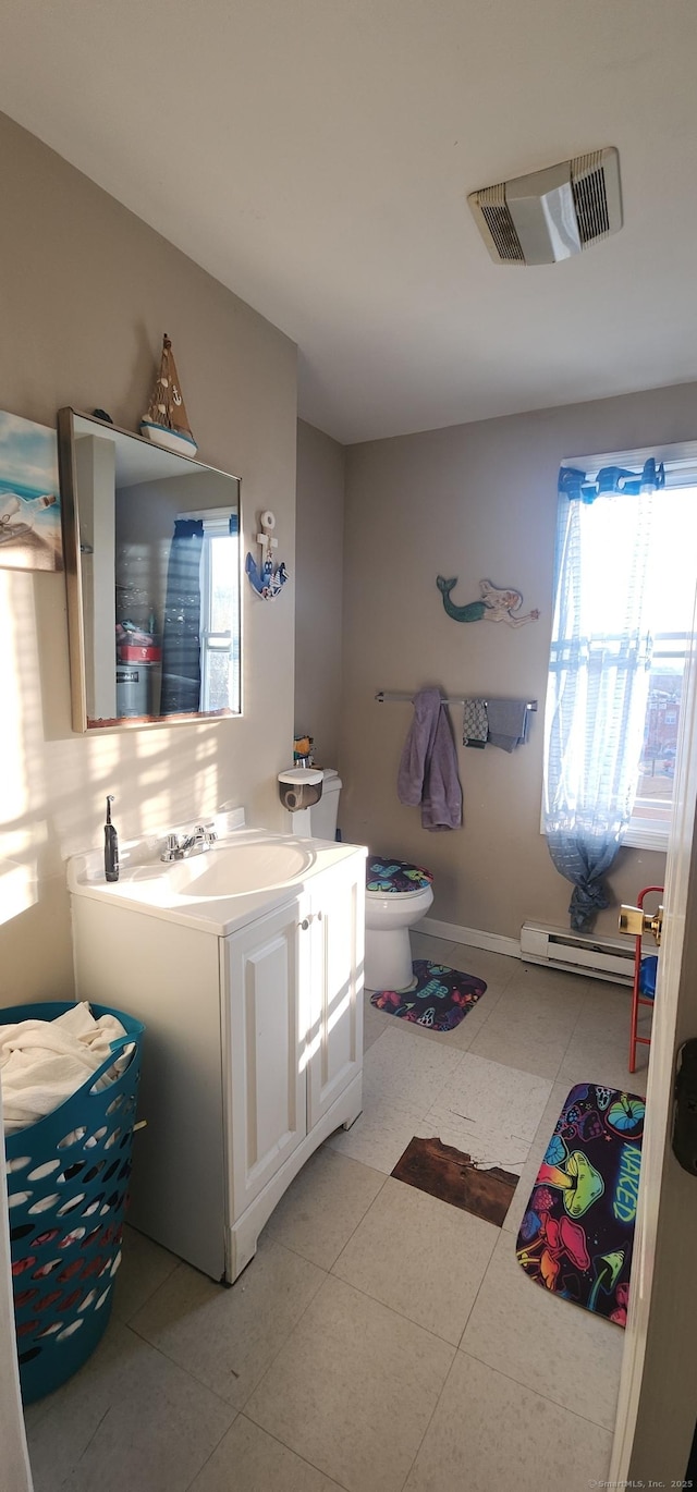 bathroom with baseboard heating, tile patterned floors, vanity, and toilet