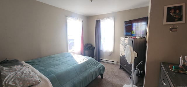 bedroom with carpet and a baseboard heating unit