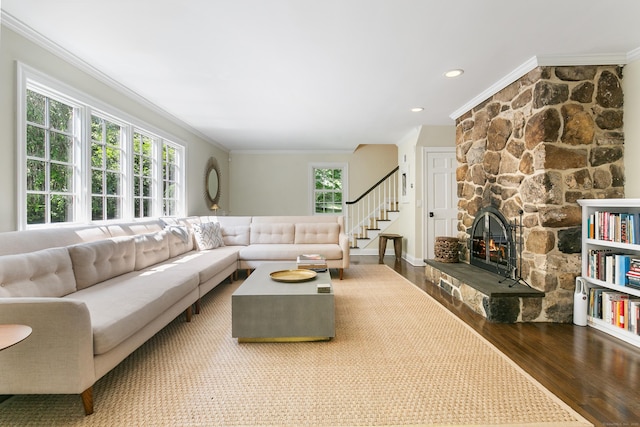 living room with a stone fireplace, crown molding, and wood-type flooring