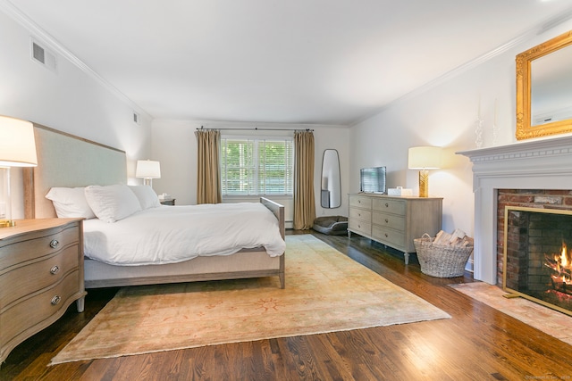 bedroom featuring hardwood / wood-style flooring, a baseboard radiator, crown molding, and a fireplace