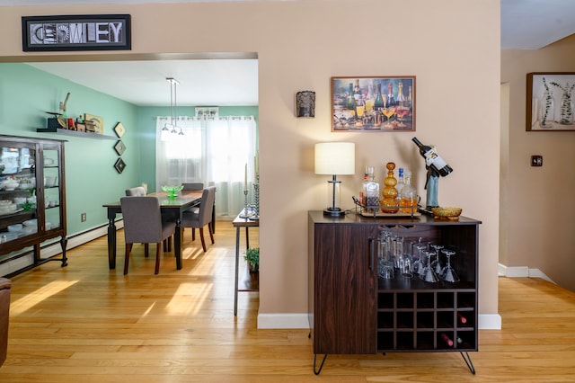 dining area with light wood-type flooring and a notable chandelier