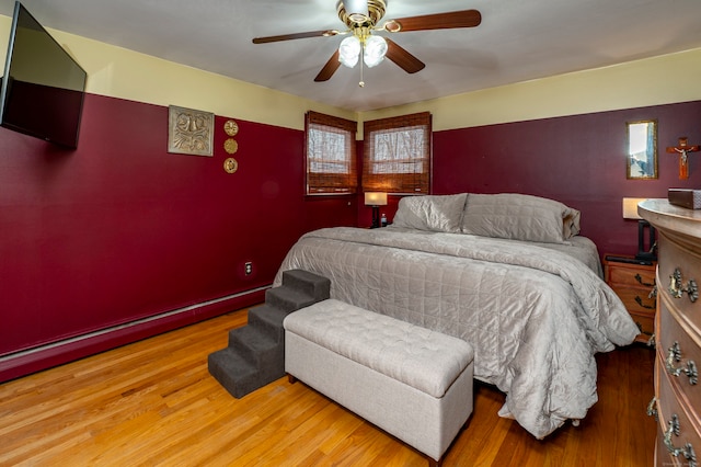 bedroom featuring ceiling fan, a baseboard radiator, and hardwood / wood-style floors