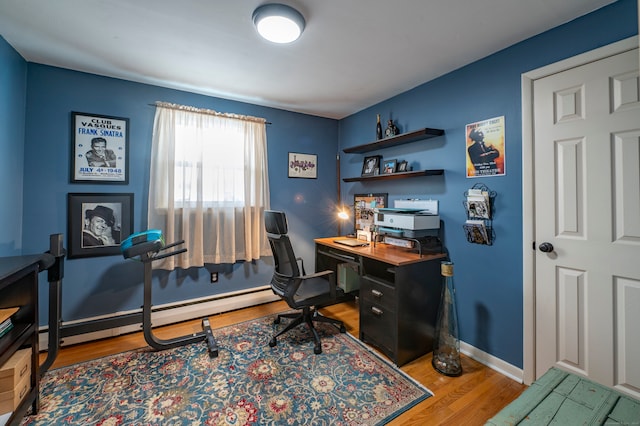 office with light hardwood / wood-style floors and a baseboard heating unit