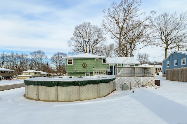 snow covered house with a swimming pool side deck