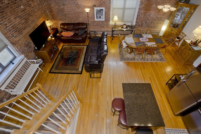 living room with brick wall and wood-type flooring