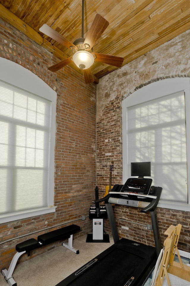 exercise room featuring brick wall and ceiling fan