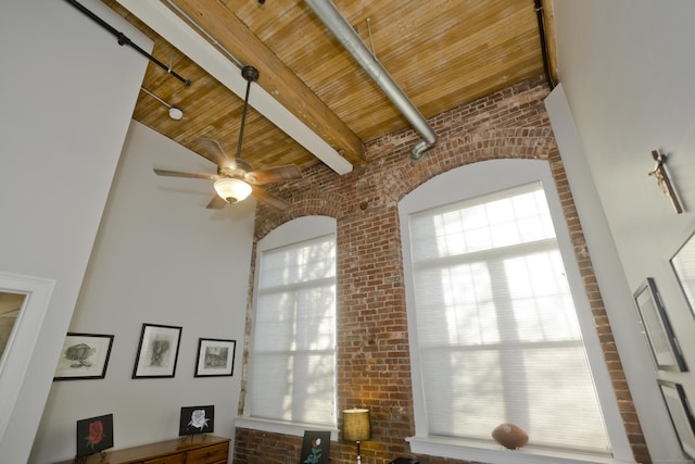 living room with beamed ceiling, brick wall, ceiling fan, and wood ceiling