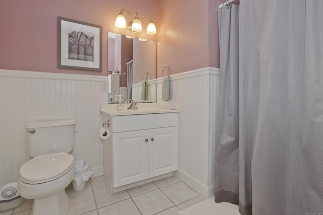 bathroom featuring toilet, vanity, tile patterned floors, and curtained shower