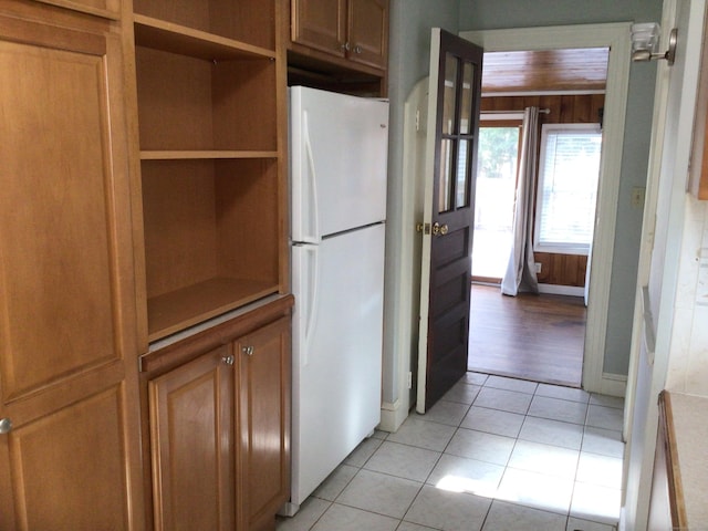 kitchen with light tile patterned floors and white fridge