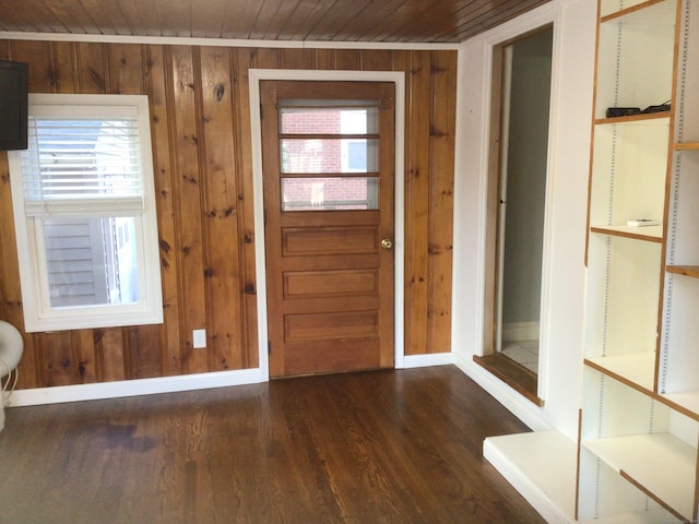 foyer with wood ceiling, a healthy amount of sunlight, and wood walls