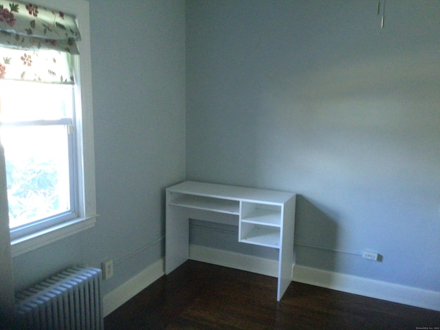 interior space with hardwood / wood-style floors and radiator heating unit