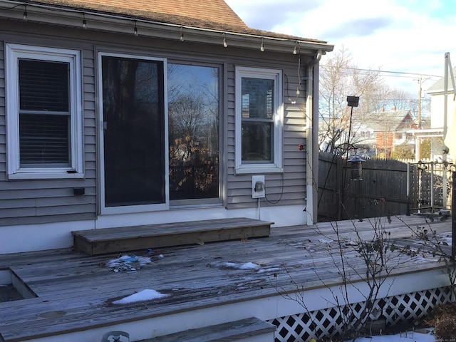 view of home's exterior featuring entry steps, roof with shingles, fence, and a wooden deck