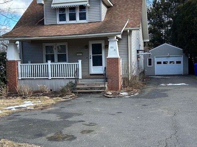 view of front of house with a porch, a garage, and an outdoor structure