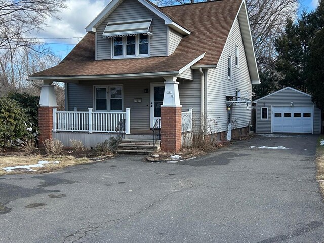 view of front of property with a garage, an outdoor structure, and covered porch