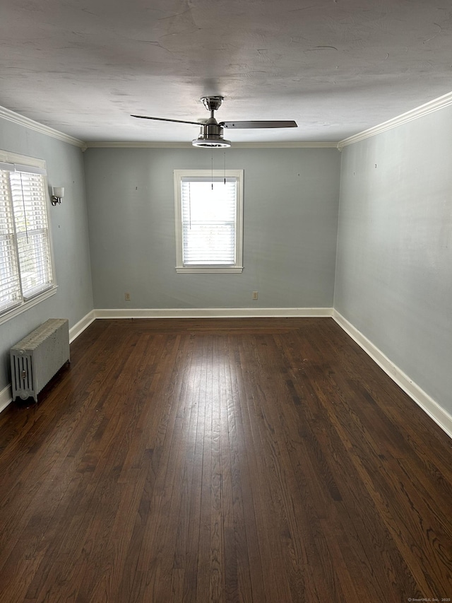 empty room with crown molding, baseboards, dark wood-style floors, and radiator