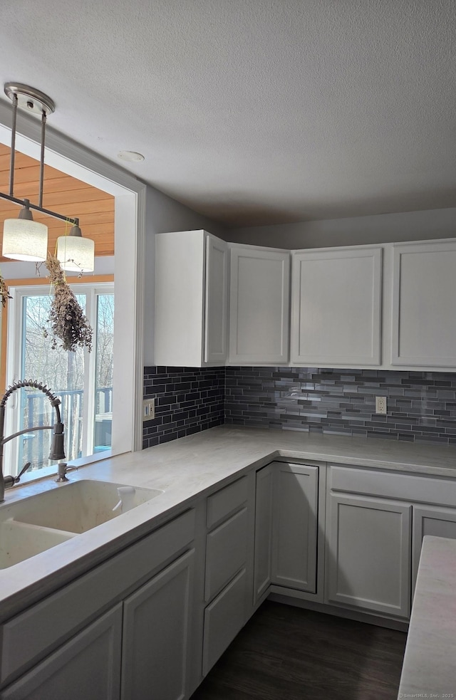 kitchen with light countertops, tasteful backsplash, and a sink