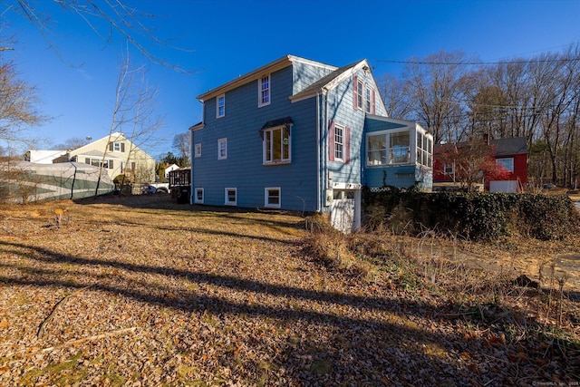 rear view of house with a sunroom and a yard