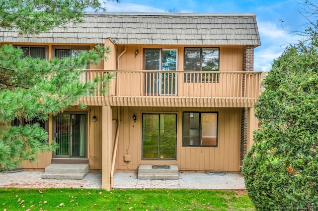 rear view of property featuring a balcony