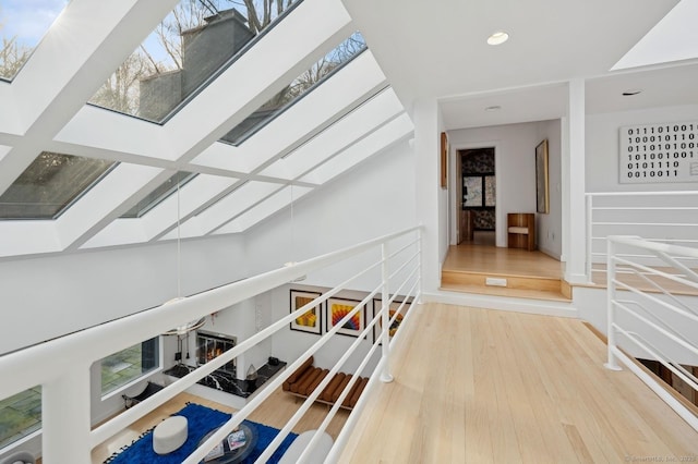 corridor featuring a skylight and hardwood / wood-style floors