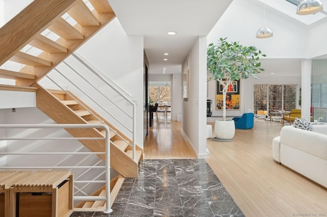 stairs featuring a towering ceiling and hardwood / wood-style flooring