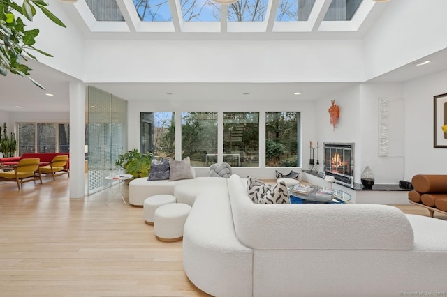 living room with a towering ceiling and light wood-type flooring