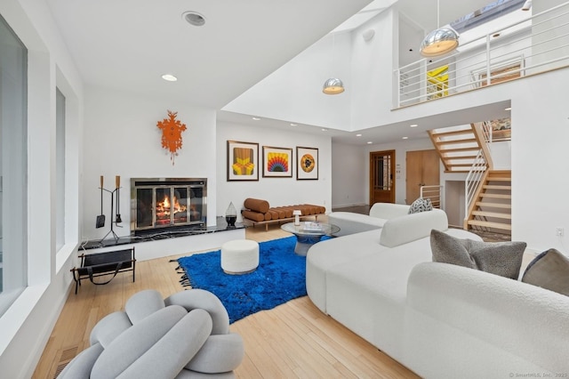 living room featuring a towering ceiling and light hardwood / wood-style flooring