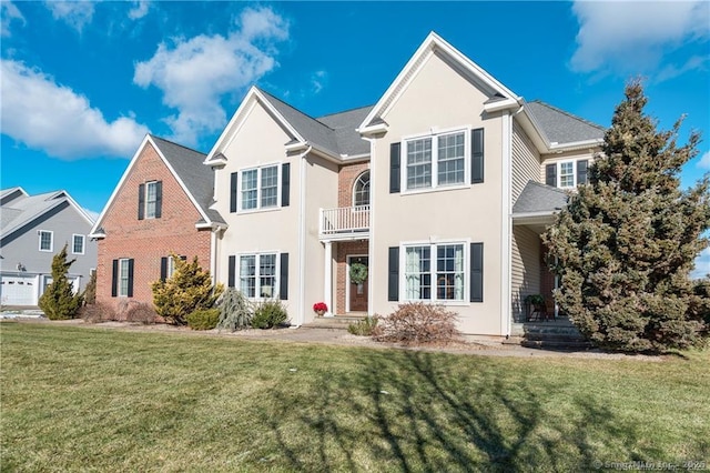 front of property featuring a front lawn and a balcony