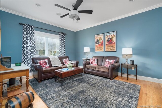 living room featuring ceiling fan, ornamental molding, and hardwood / wood-style flooring