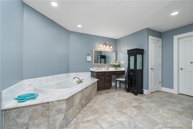 bathroom with tiled bath and vanity